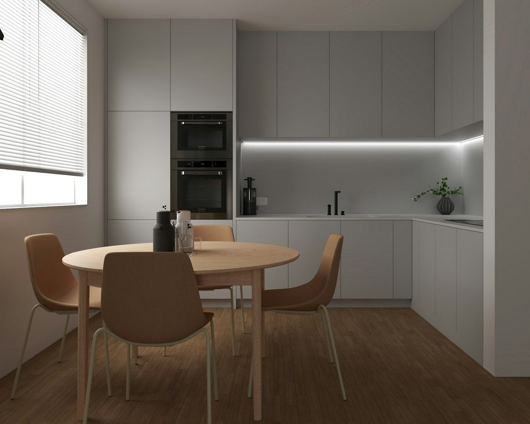 Compact apartment dining area with small table and chairs beside a window