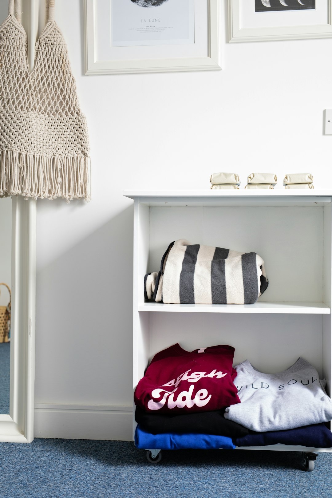 Neatly folded clothes organized on a small apartment closet shelf