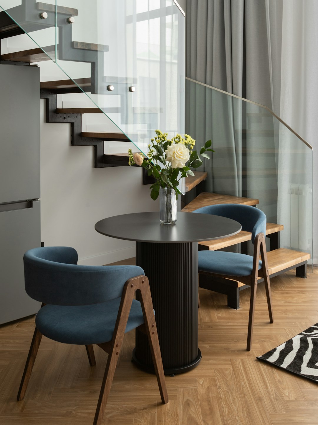 Round compact dining table with two chairs for a studio apartment