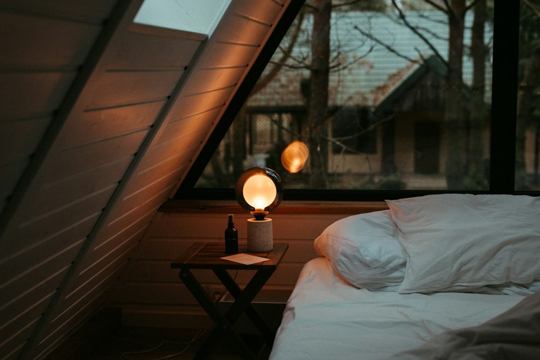 Small bedroom with bed under a window and a compact bedside table
